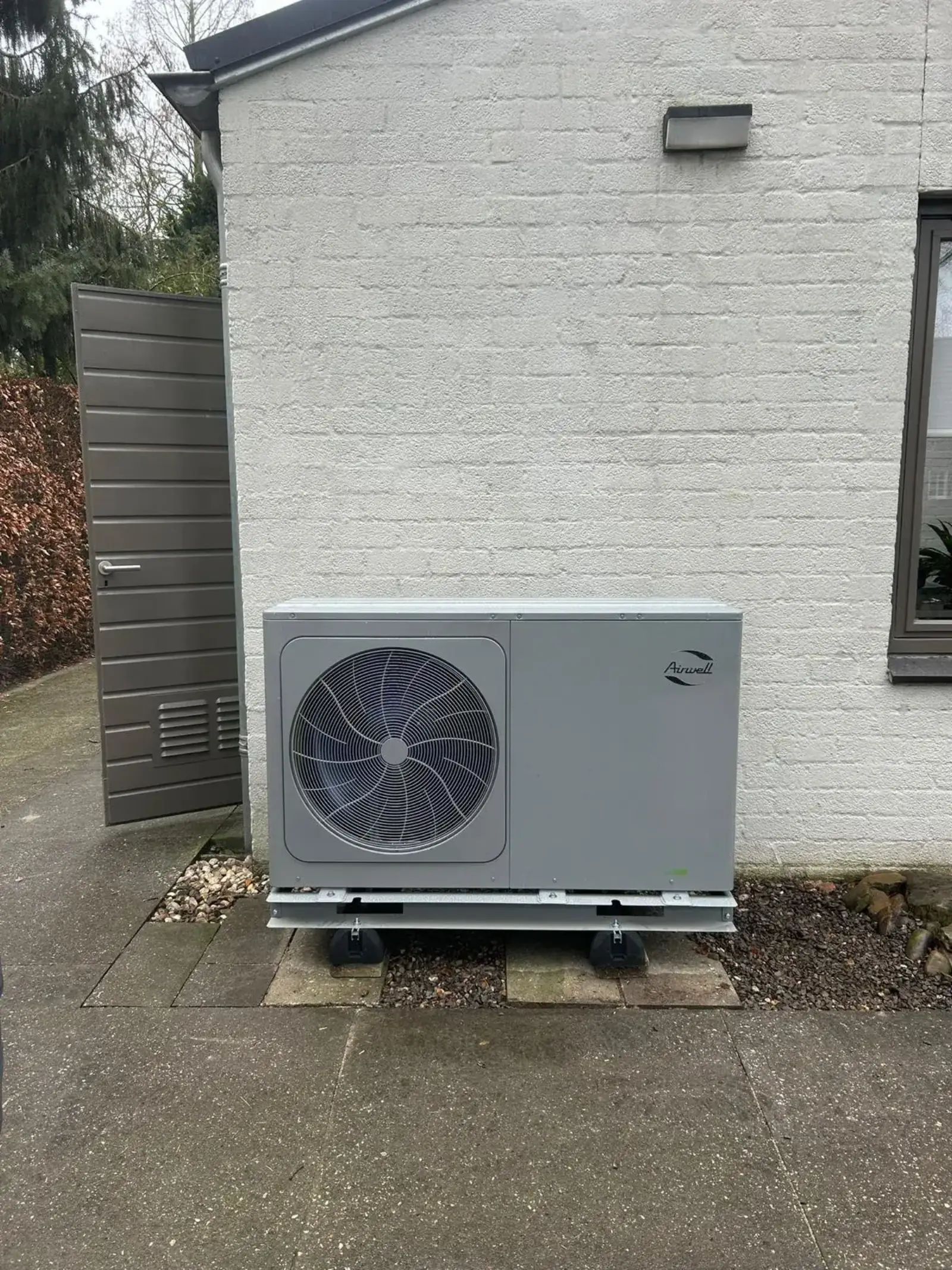 Airwell warmtepomp naast schuur
