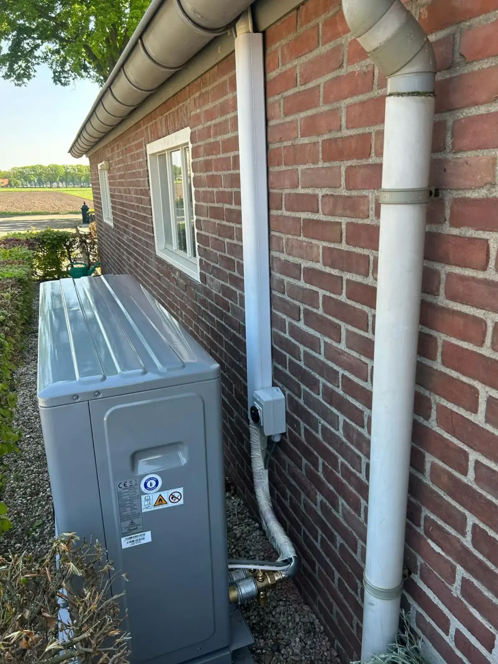 Airwell warmtepomp zijkant woning